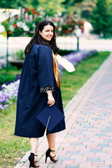 Happy student woman on graduation day outdoors