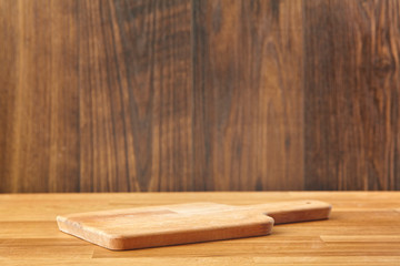 Background with cutting board on wooden table. Copy space