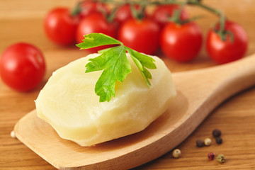 Boiled potatoes in the wooden poon, parsle board Close up