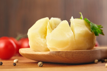 Boiled potatoes in the wooden poon, parsle board Close up