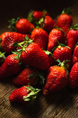 group of ripe strawberries on a wooden table