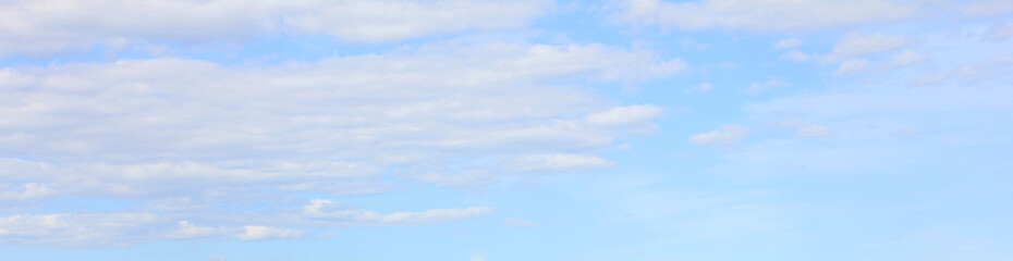 Light blue cloudy sky background. Pale bright blue sky nature, tiny white clouds pattern. Horizon cloudscape view, natural gradient sky template