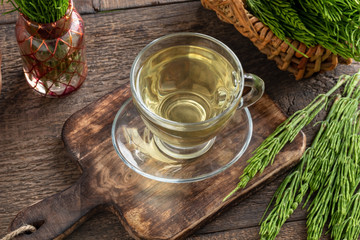 A cup of herbal tea with fresh horsetail