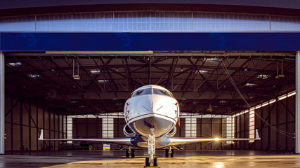 Jet privé à la sortie d'un hangar aéronautique