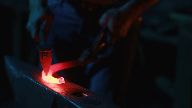 A blacksmith forging horseshoes for horses