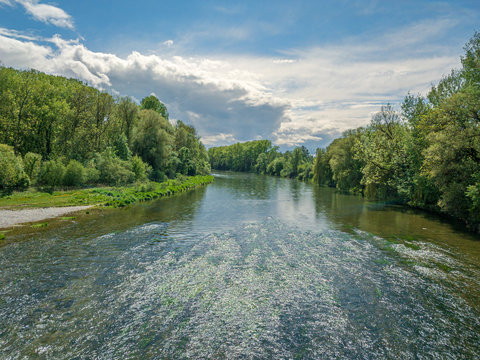 The Bavarian Isar River with blue and white cloudy sky during spring