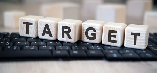 Target - text cubes stand on a black keyboard on a wooden table
