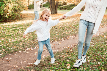 Happy daughter with mother is having fun walking in the park.