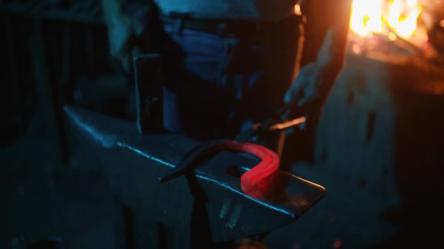 A blacksmith forging horseshoes for horses