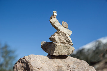Fototapeta premium A figure of stones against the background of a clear sky. Stone pyramid.