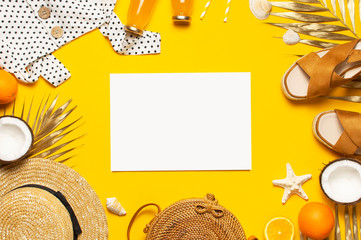 Flat lay Summer background Beach wicker straw rattan women's eco bag white dress hat sandals blank album notepad golden tropical leaf coconut orange juice shells starfish on yellow background top view