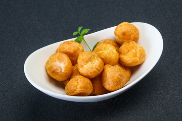 Sweet tasty profiteroles heap in the bowl