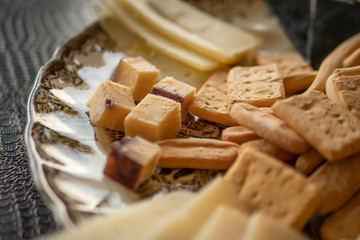 Plato con diferentes tipos de queso y pan crujiente.
