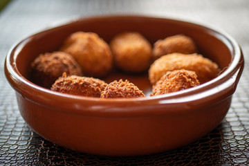 Ración de croquetas caseras en cazuela de barro.
