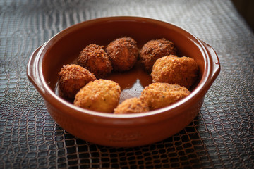Ración de croquetas caseras en cazuela de barro.