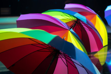 A group of multi-colored umbrellas on stage during a concert.