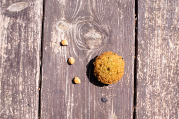 falafel balls from hummus on the wooden table with design lemon and parsley on wooden background with cilantro Vegetarian dish -  from spiced chickpeas food flat lay