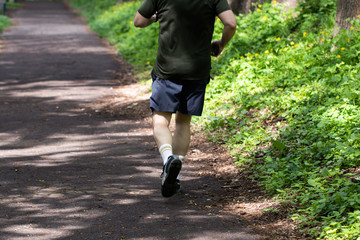 Young man runs in the park. Morning run