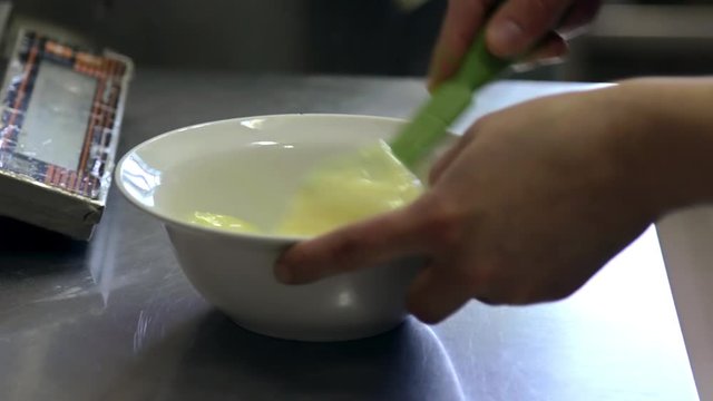 chef whips eggs by corolla in soup plate