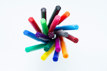 Set of multi-colored markers in a cup on white background. Top view.