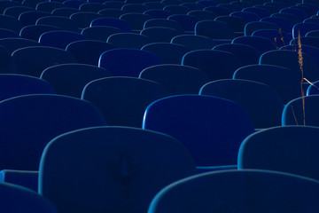 The backs of old armchairs in blue at a football stadium. Remind fish scales