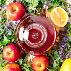 Glass teapot with herbal tea, various fruits, herbs and flowers top view, copy space. Natural...