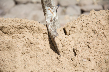 Fototapeta premium Steel Shovel for scoop sand in construction work. Front view to construct the building background.