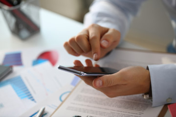 A businessman holds a new smartphone
