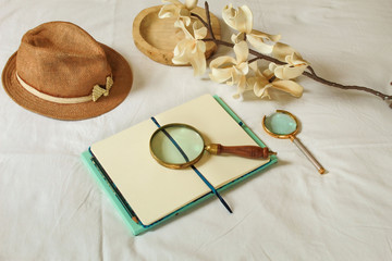 Imagen elegante de un espacio de trabajo con elementos de investigaci&oacute;n como un cuaderno para un trabajo de campo sombrero y lupas 