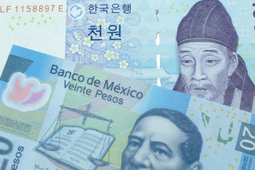 A blue two thousand won note from South Korea close up in macro with a twenty peso note from Mexico