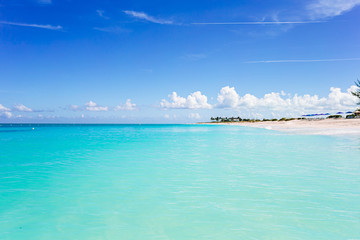 Idyllic tropical beach in Caribbean with white sand, turquoise ocean water and blue sky