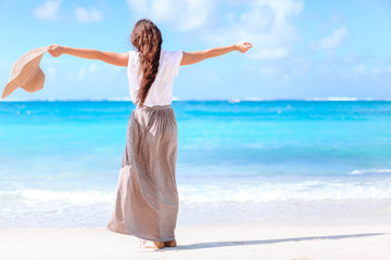 Young beautiful woman having fun on tropical seashore. Happy girl background the blue sky and...