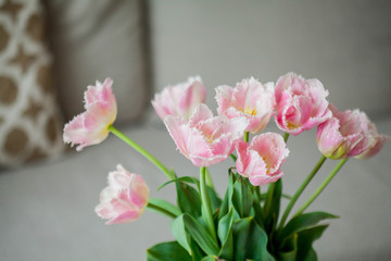 Naklejka na ściany i meble Bouquet of pink tulips in a vase in a home interior