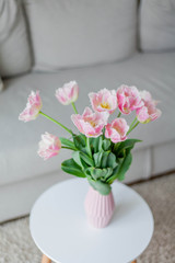 Bouquet of pink tulips in a vase in a home interior