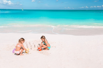 Fototapeta na wymiar Two kids making sand castle and having fun at tropical beach