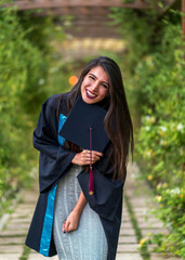 Woman taking a lot of different graduation photos in a beautiful botanical park.
