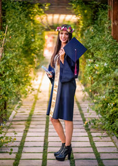 Woman taking a lot of different graduation photos in a beautiful botanical park.