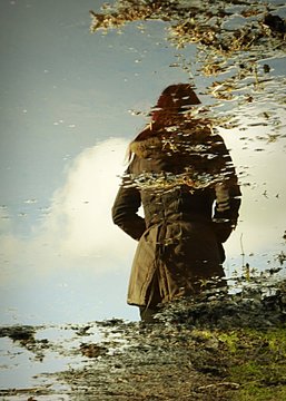 High Angle View Of Woman Reflection In Puddle