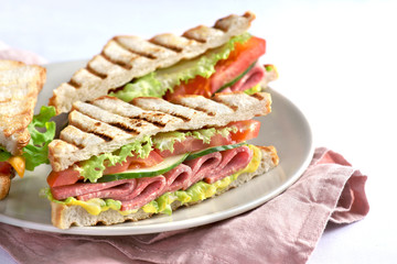 sandwich with sausage and cheese sauce on a light background