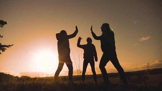 teamwork business journey concept win. happy family a team man, woman and kids sunset silhouette help shake hands victory success lifestyle . slow motion video. tourism husband and wife on top