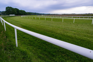 Empty horse racing track, dark grey sky background