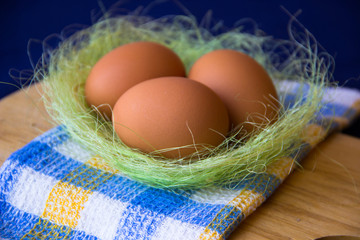 Chicken eggs. Brown chicken eggs in basket on the cutting board, close up. Still life with eggs. Farm natural products. Eggs are ingredient for cooking. Health food. Happy Easter concept.