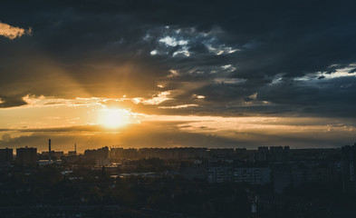 Golden sunset dark clouds over the city