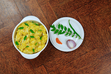 Tasty south indian kappa puzhukku, cooked tapioca in a white bowl isolated on wooden background