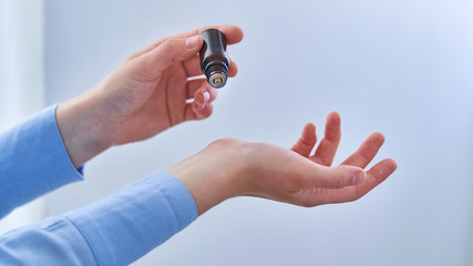 Woman applying natural herbal essential perfume oil on the wrist