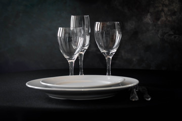 primer plano de mesa con platos cuchillo tenedro copas y luces led 