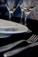 primer plano de mesa con platos cuchillo tenedro copas y luces led 
