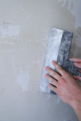 align the old walls with a finishing putty using a spatula