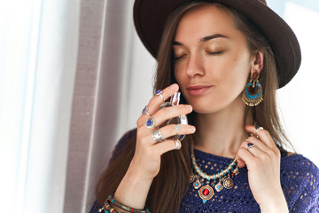 Stylish fashionable attractive sensual brunette boho chic woman with closed eyes wearing jewelry...