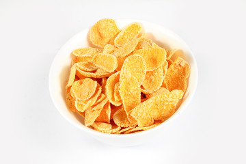 close up of muesli with dried fruits and yogurt in bowl on white background